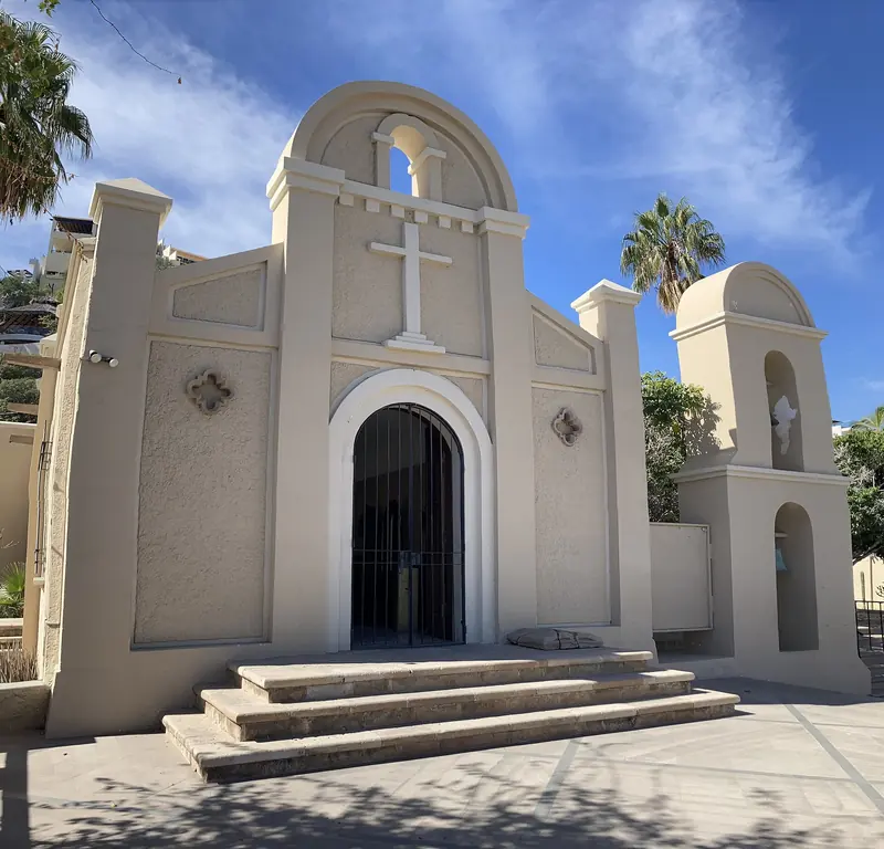 White facade of the San Lucas parish church in Cabo San Lucas, with its cross and bell tower