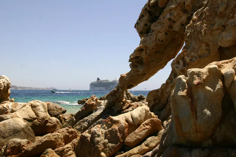 Rocas de Playa del Amor con un crucero anclado en la bahía detrás