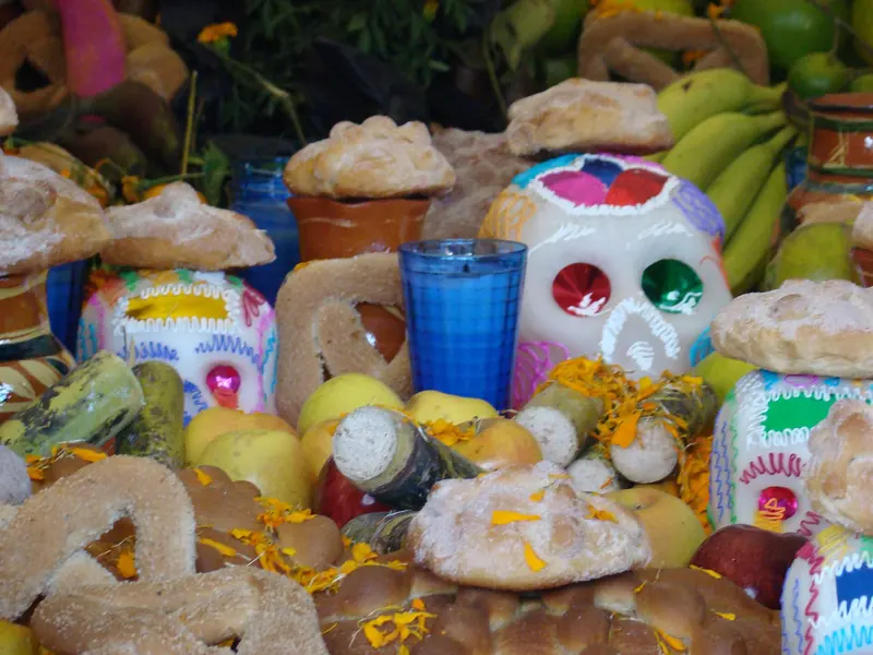 Day of the Dead altar with pan de muerto, sugar skulls and fruit in Mexico City