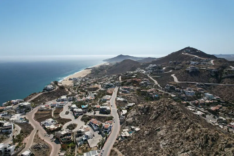 Aerial view of hillside homes and roads above the Pacific coast of Cabo San Lucas