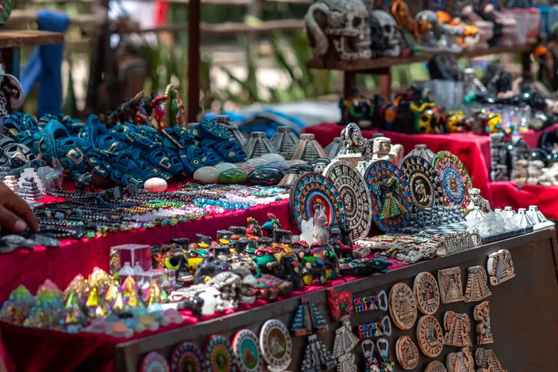 A market stall full of handmade Mexican crafts and souvenirs on red tablecloths