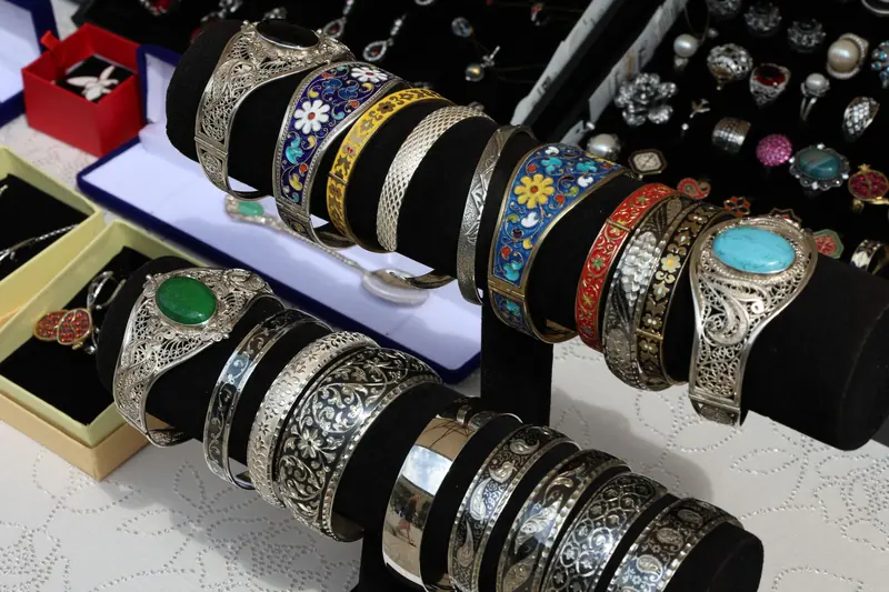 Pulseras de plata con incrustaciones de colores en un puesto de joyería