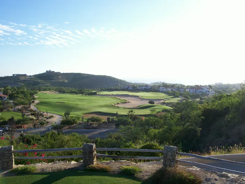 Fairways and greens at Palmilla golf course with houses on the hills behind