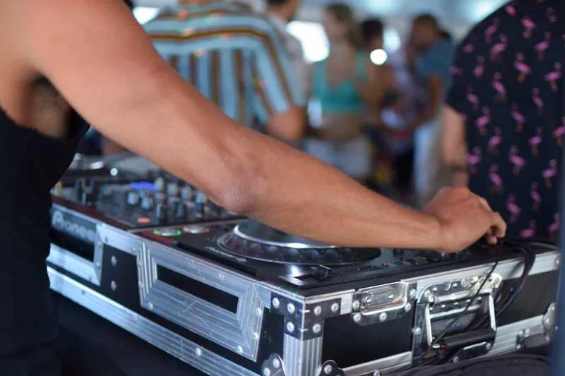 DJ Basneit's hands on his controller in its road case, on deck during a yacht charter in Cabo