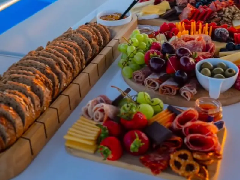 Tablas de charcutería, fruta fresca y pan servidos en la cubierta de un yate privado