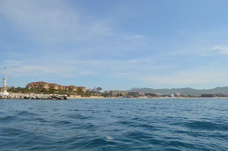 Hoteles a lo largo de Playa El Médano vistos desde el mar, con los cerros atrás