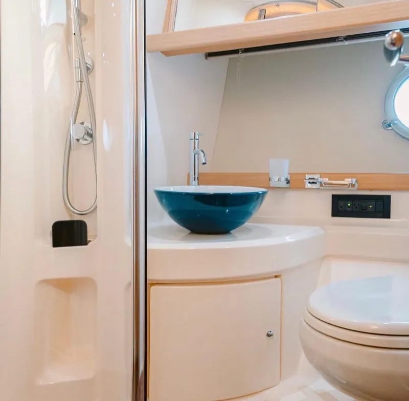 One of the two private heads aboard the Azimut 45, with a separate shower stall, vessel sink and porthole