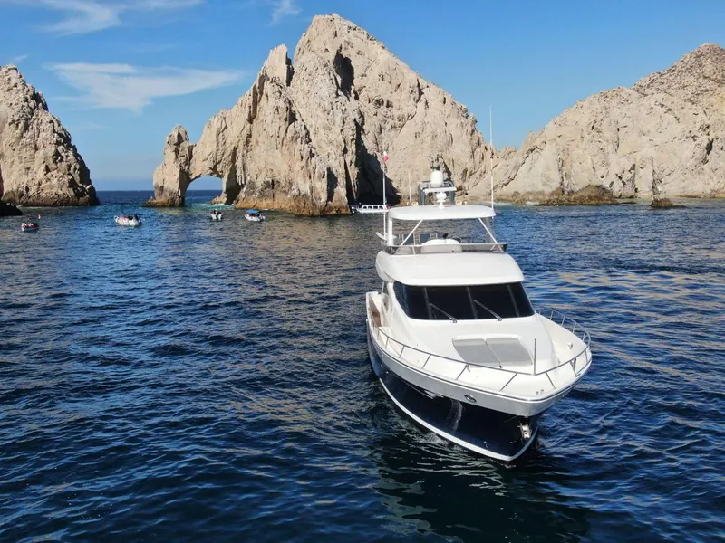 The McKinna 70 luxury motor yacht on dark blue water in front of the Arch at Land's End