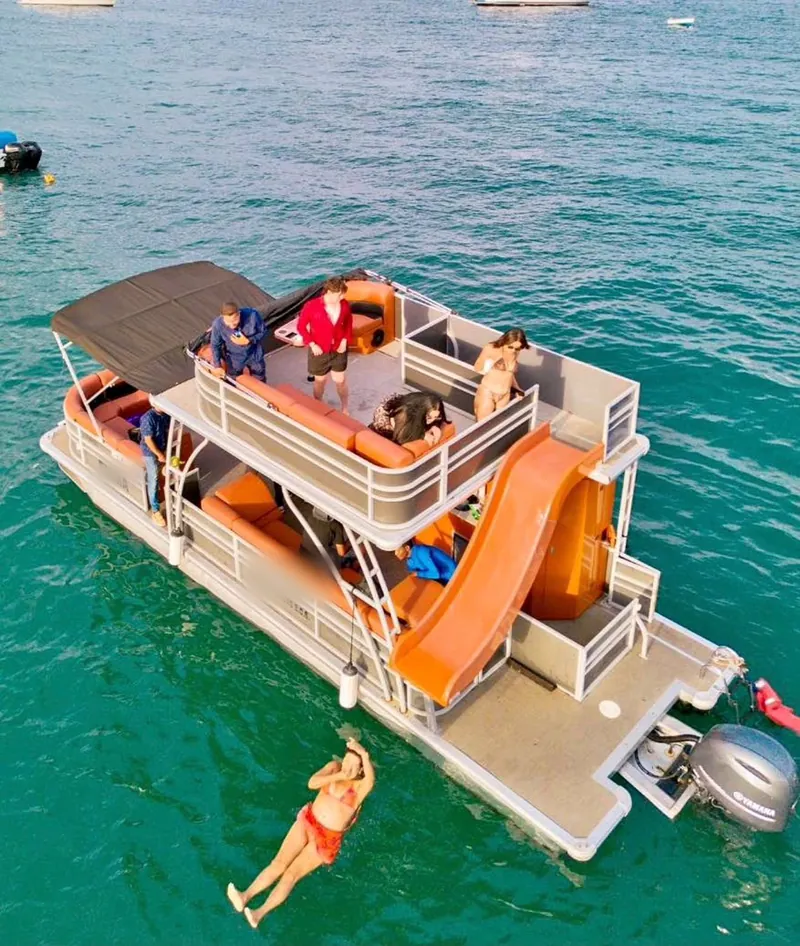 Guests on the upper sun deck of the Pontoon 38 and the water slide down to the swim platform, Cabo San Lucas