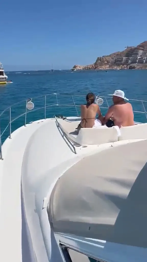 Caminando por la cubierta lateral del Sea Ray 55 hacia la proa, donde una pareja descansa en los cojines frente a la playa