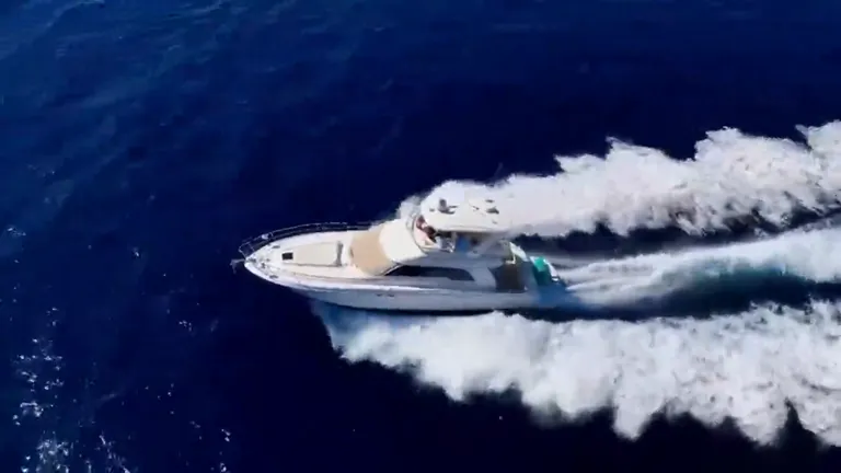 Sea Ray 55, yate a motor con flybridge navegando frente a Cabo San Lucas, visto desde el aire